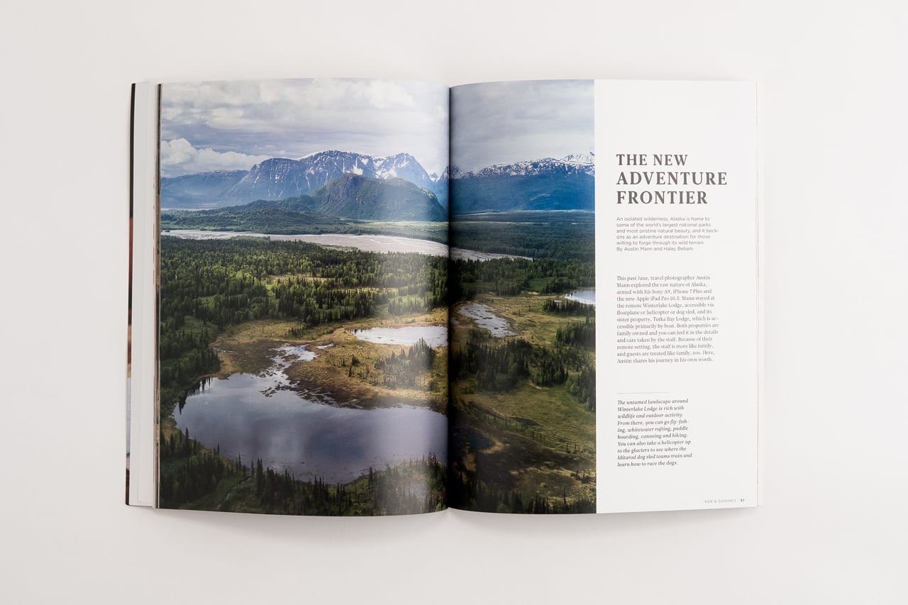 A travel booklet laying open to a forest and mountain landscape and The New Adventure Frontier.