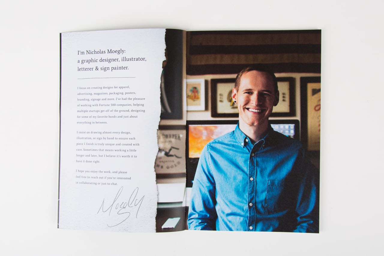 A portfolio laying open to an image of a man smiling wearing a blue shirt and information about him.