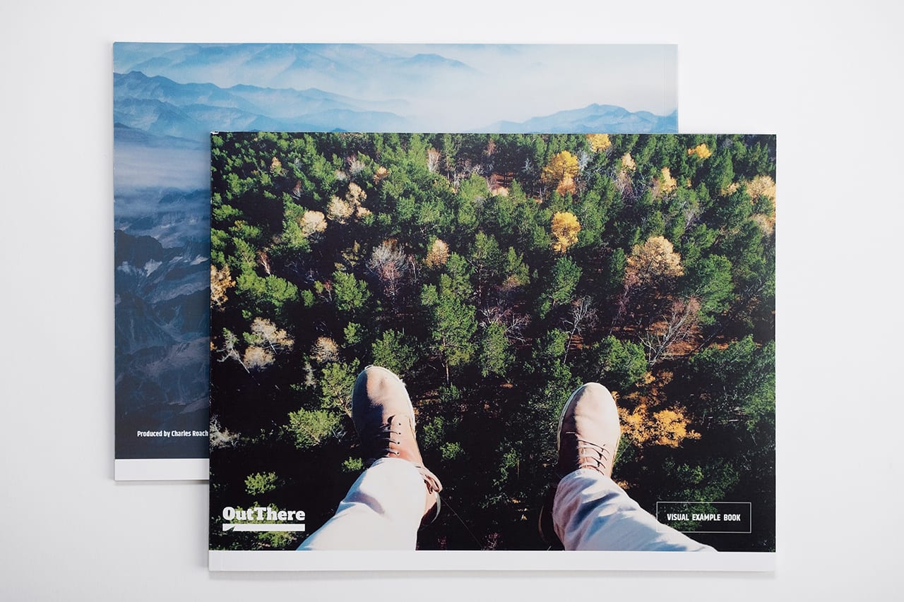 Two brand manuals overlapping each other and laying open to landscape photography.