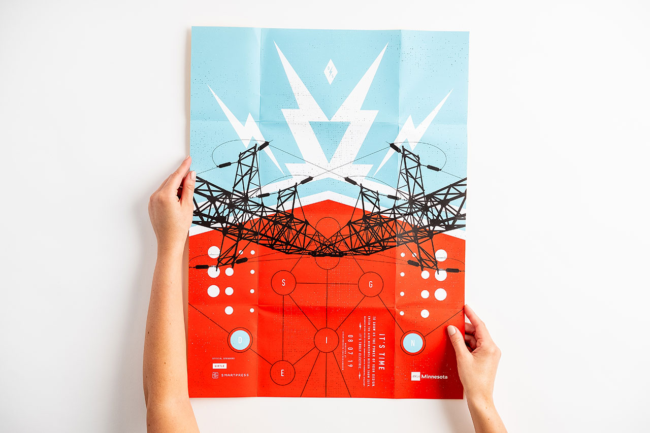 Two hands holding open a direct mailer printed with a bright orange and teal design.