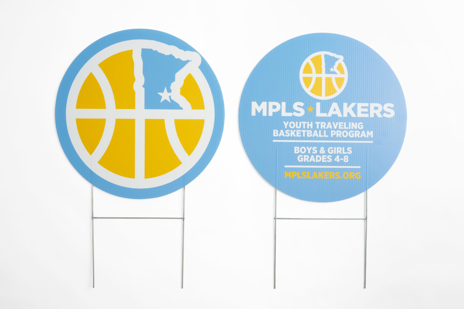 Two round yard signs printed with a light blue and yellow design and MPLS Lakers in white.