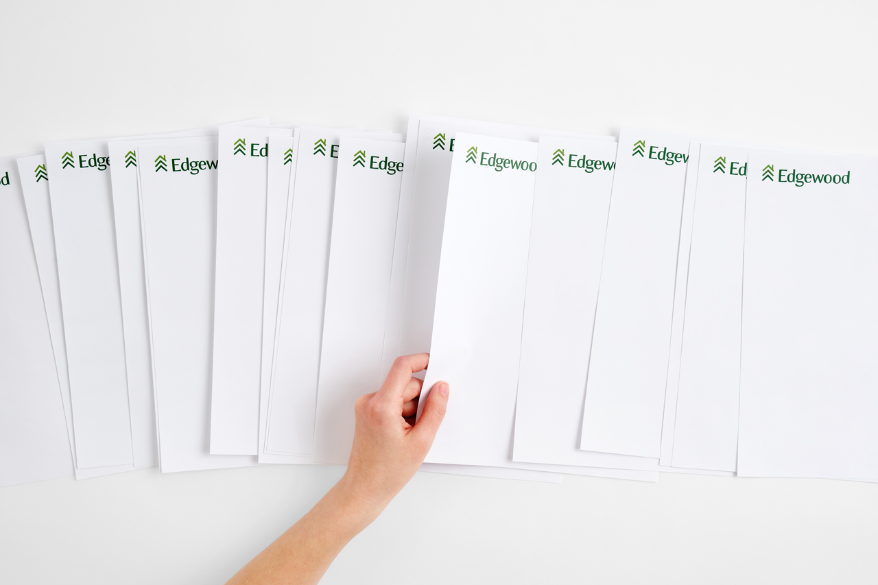 Custom letterheads fanned out in a row with a hand holding one in the middle.