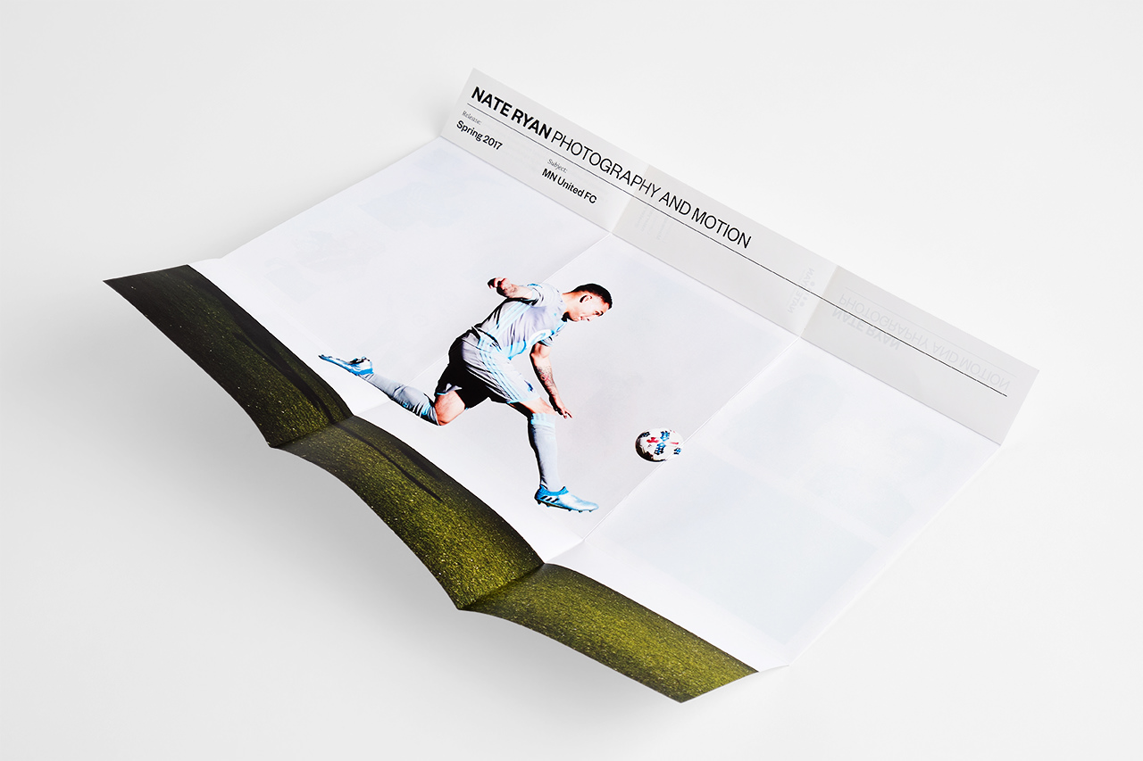 A tri-fold broadside reveal brochure unfolded to show a soccer player on the inside.