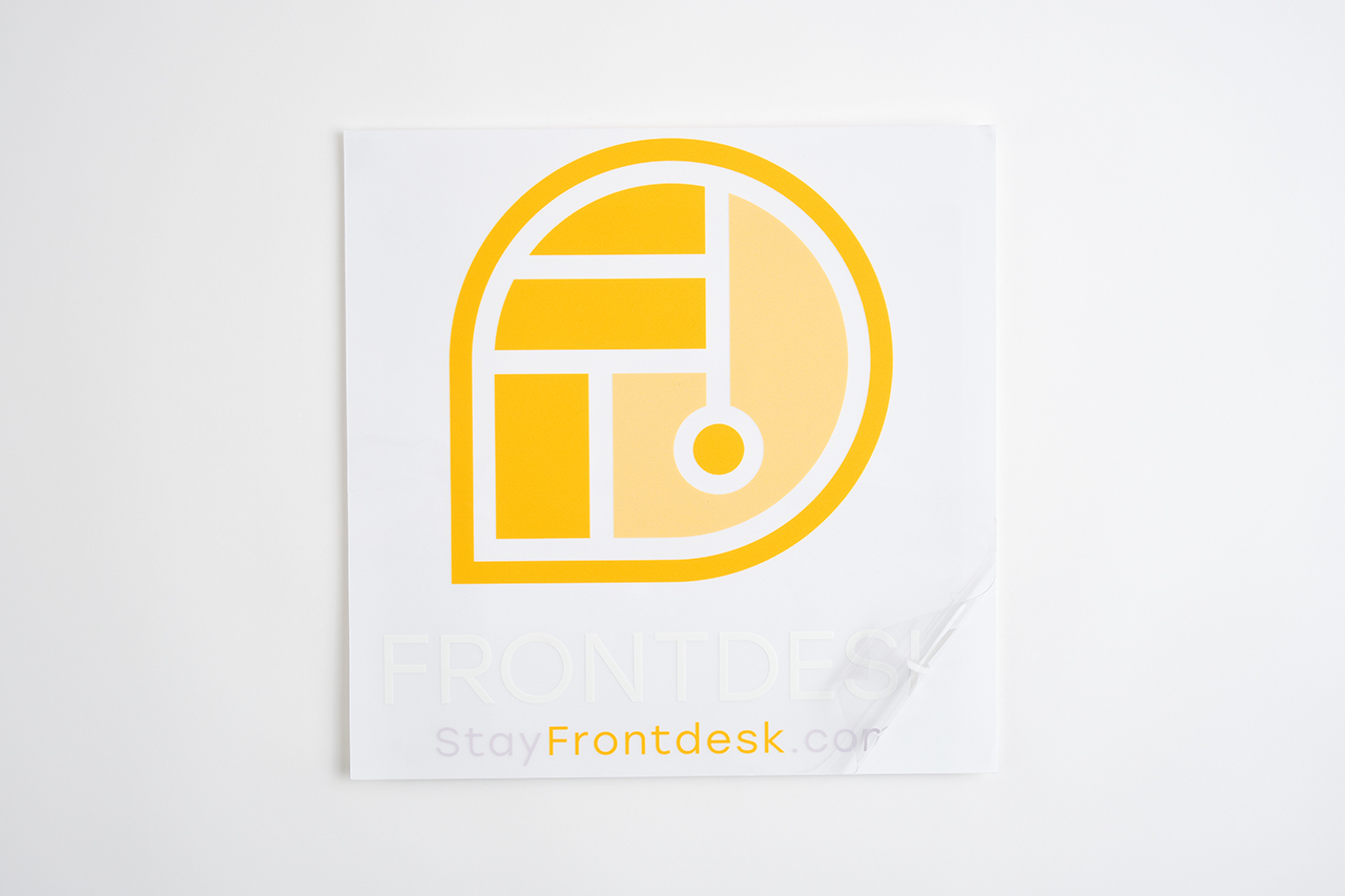 A custom window decal printed with Frontdesk in white and a round logo in yellow.