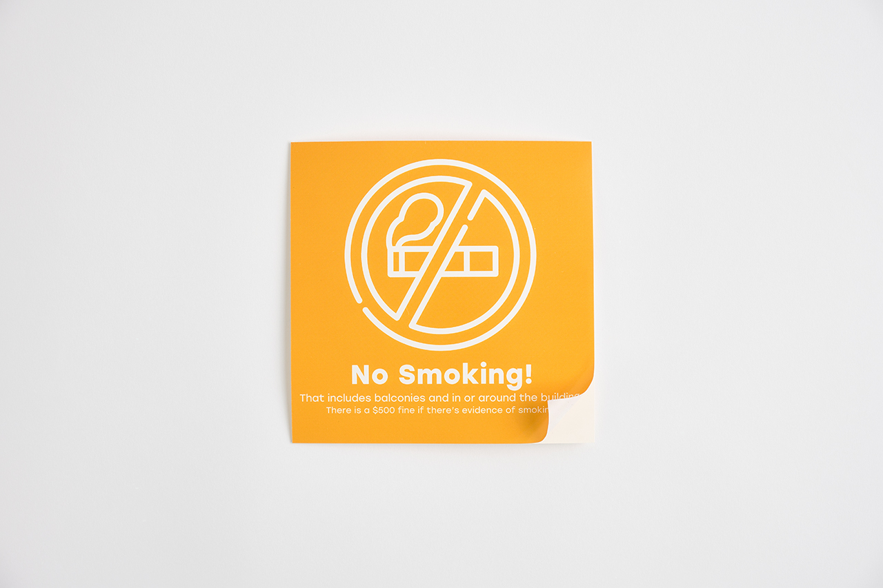A custom window decal printed with a no smoking message in yellow and white.