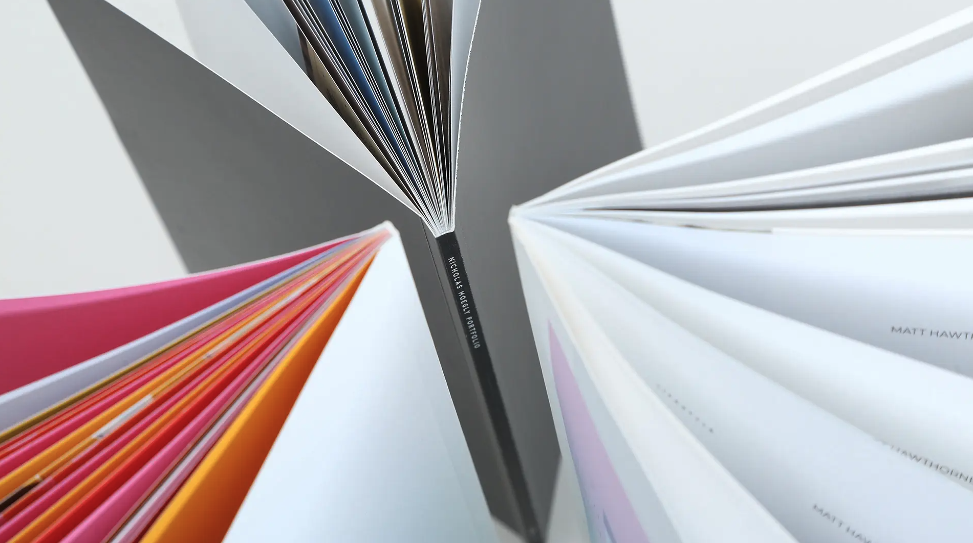 Three booklets standing in a circle with their spines in the center.