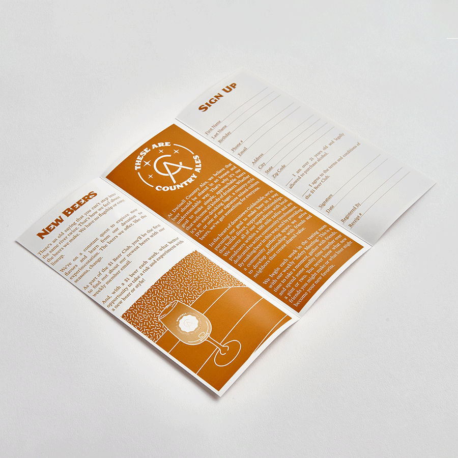 A brochure laying unfolded with an orange and white design and beer info.